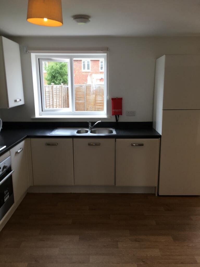A bright and modern kitchen featuring ample cou...
