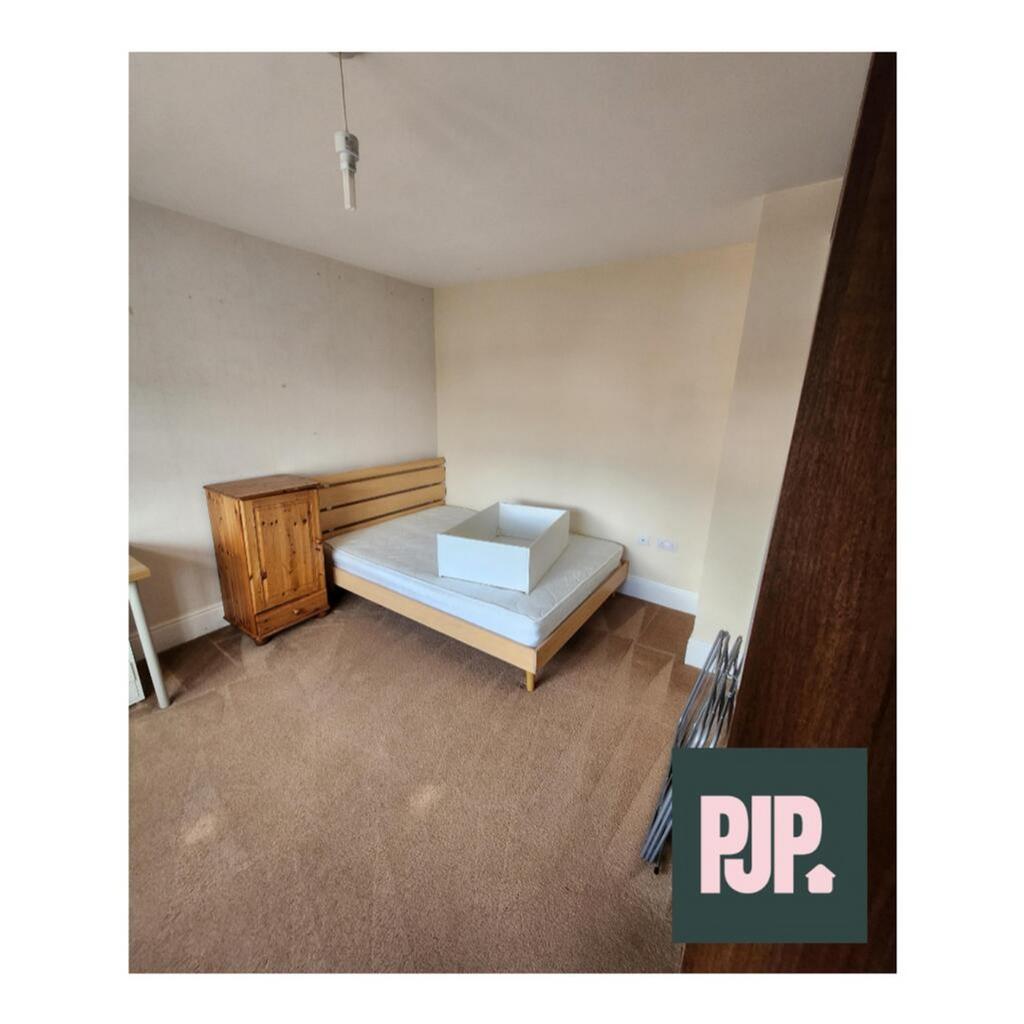 A spacious double bedroom featuring ample natur...