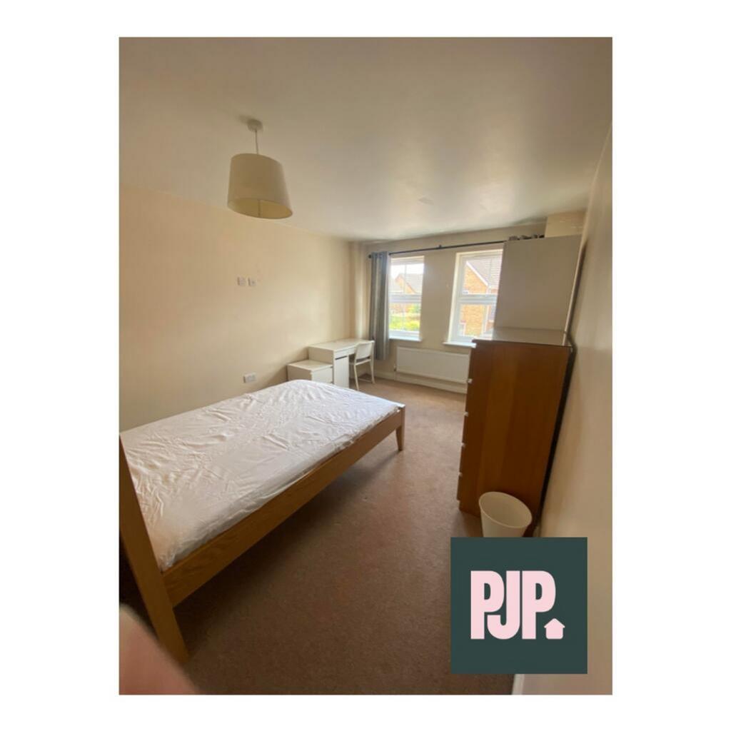 Spacious double bedroom featuring large windows...