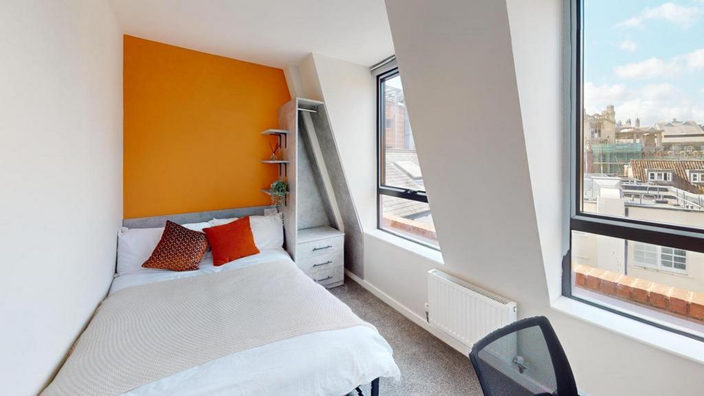 A bright and inviting double bedroom with styli...
