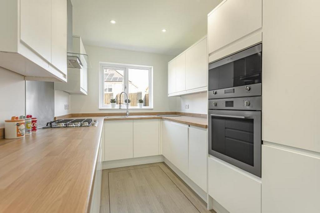 A modern kitchen featuring sleek cabinetry and ...