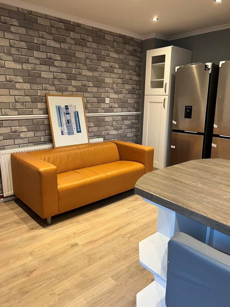 A modern kitchenette featuring a stylish orange...
