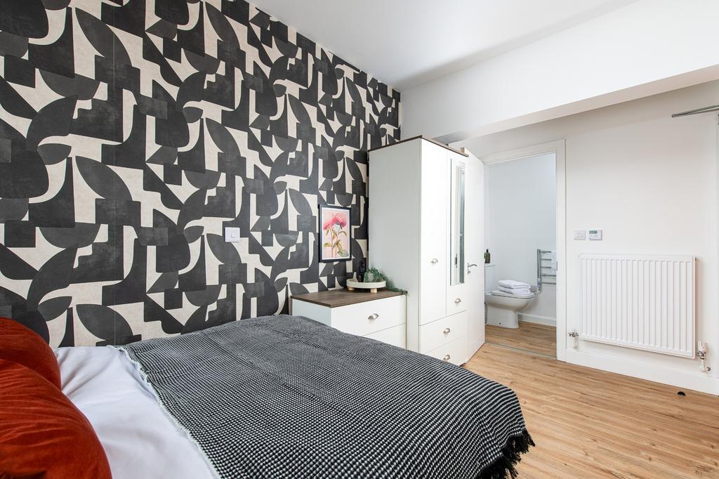 A stylish double bedroom featuring a modern des...