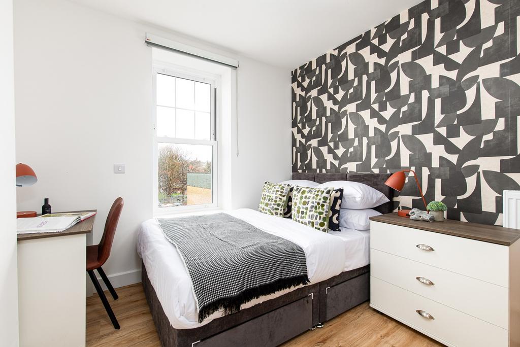 This stylish double bedroom features a comforta...