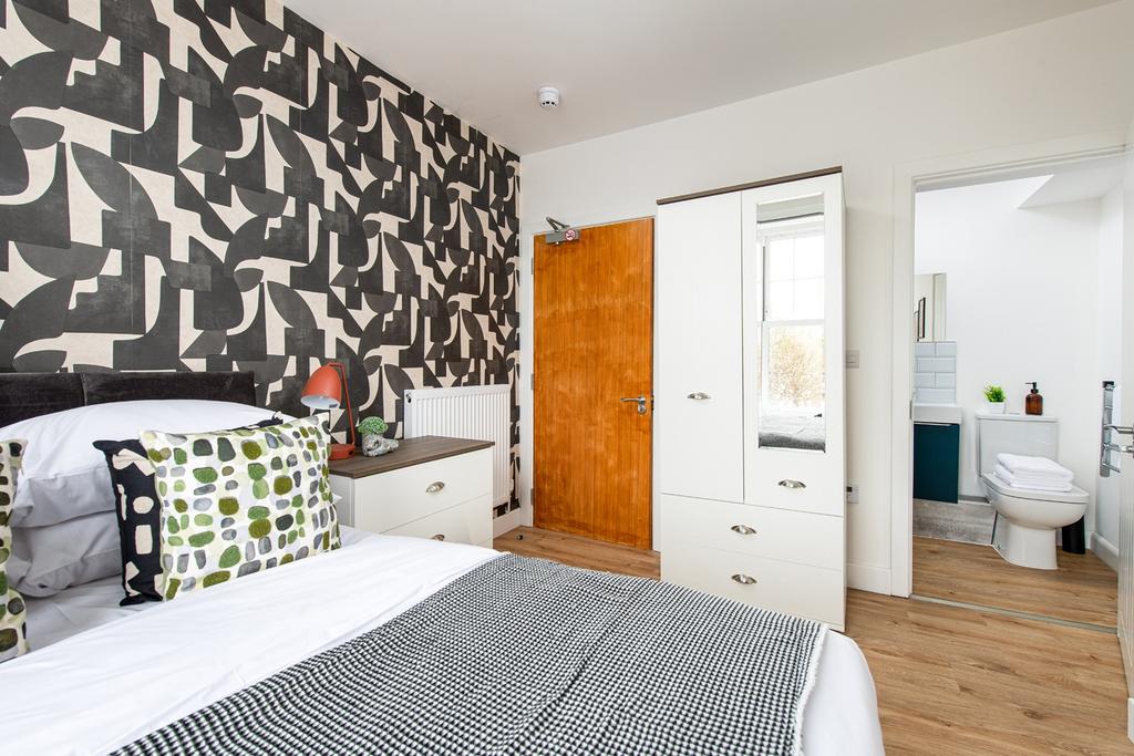 A stylish double bedroom featuring a modern des...