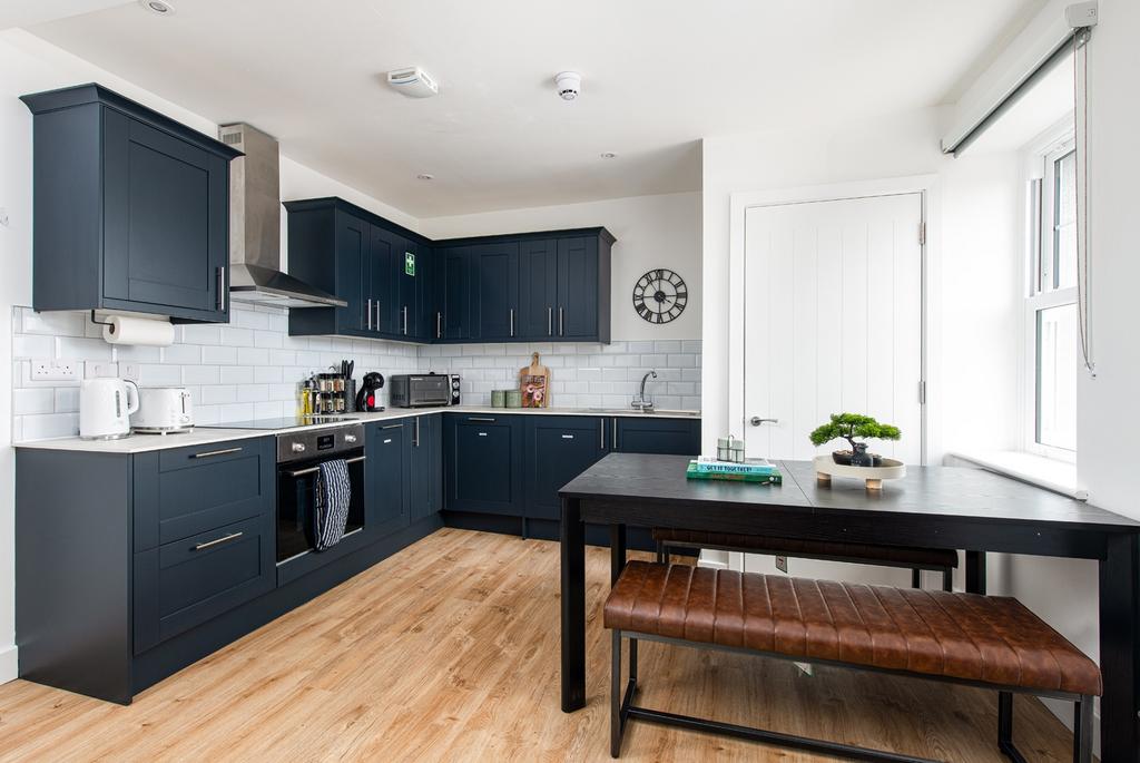 A modern kitchen featuring sleek navy cabinetry...