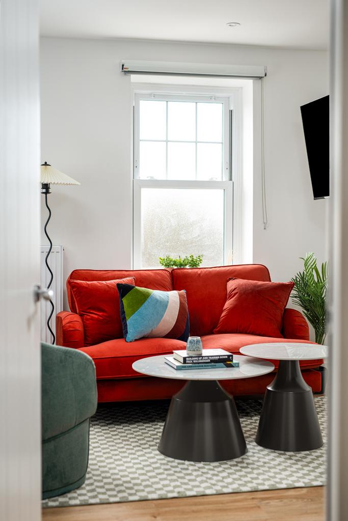 A stylish living room featuring a vibrant red s...