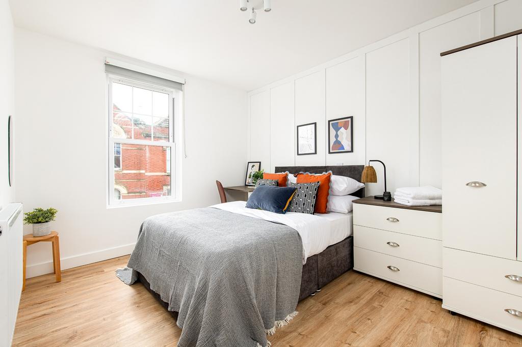 This inviting double bedroom features a cozy at...