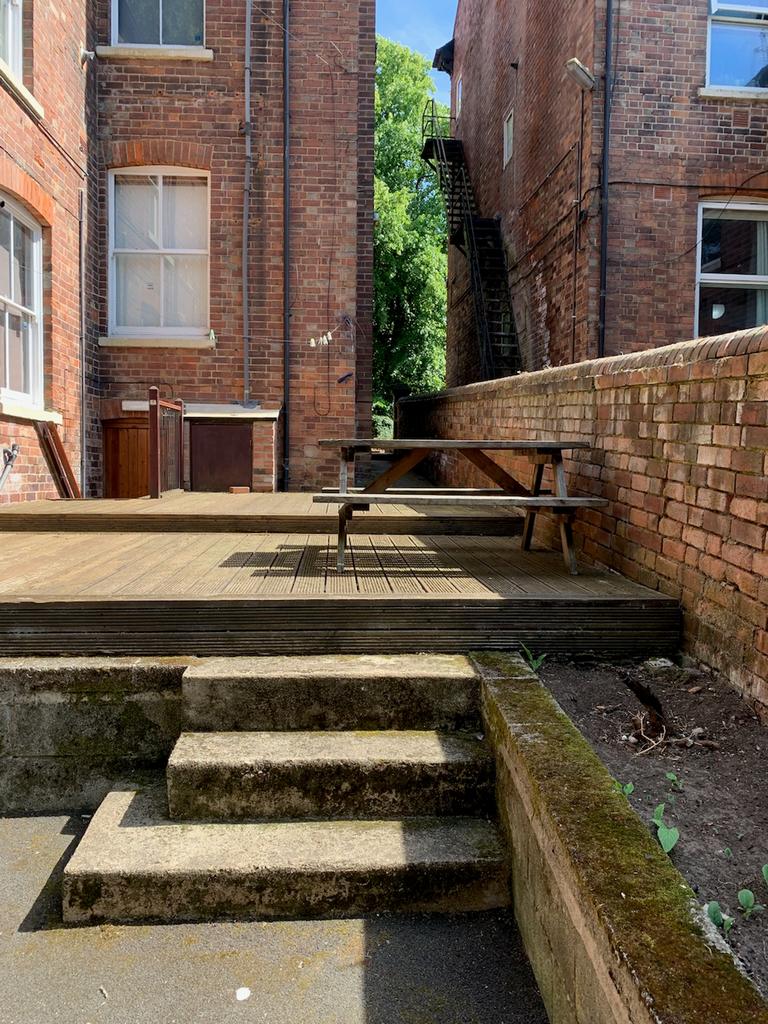 A spacious and inviting garden area with a wood...