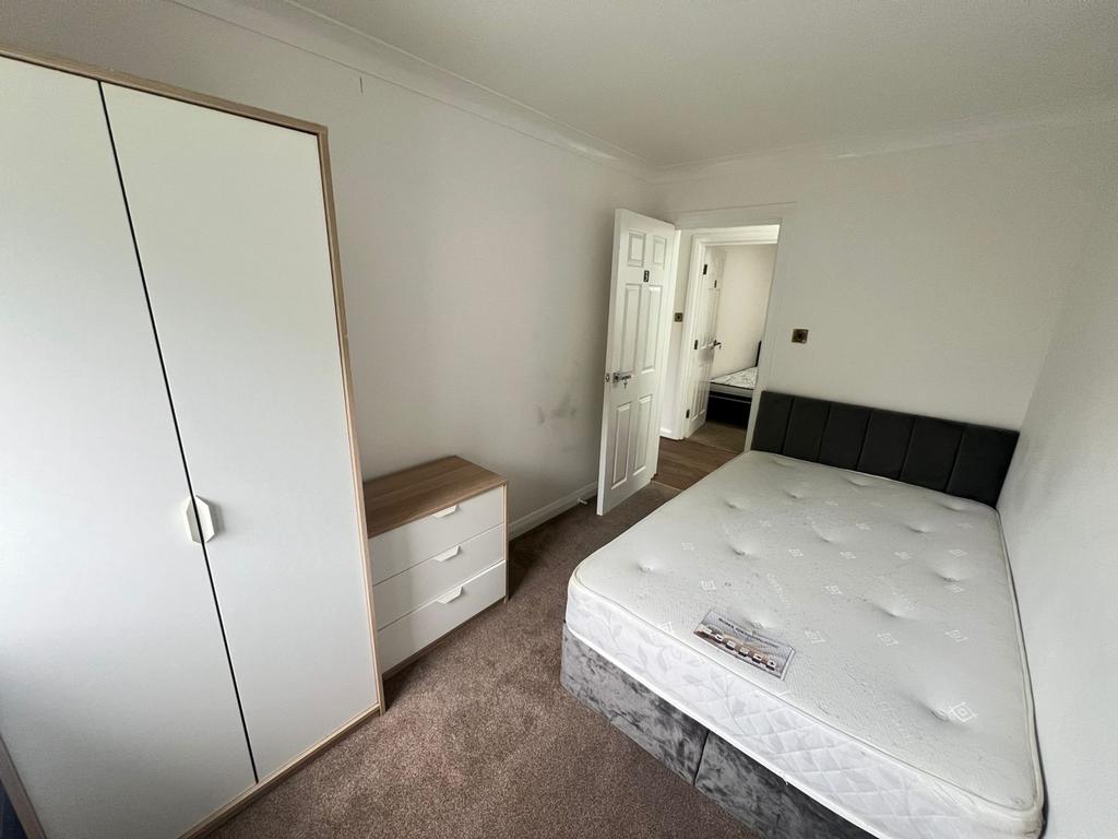 This inviting double bedroom features a comfort...