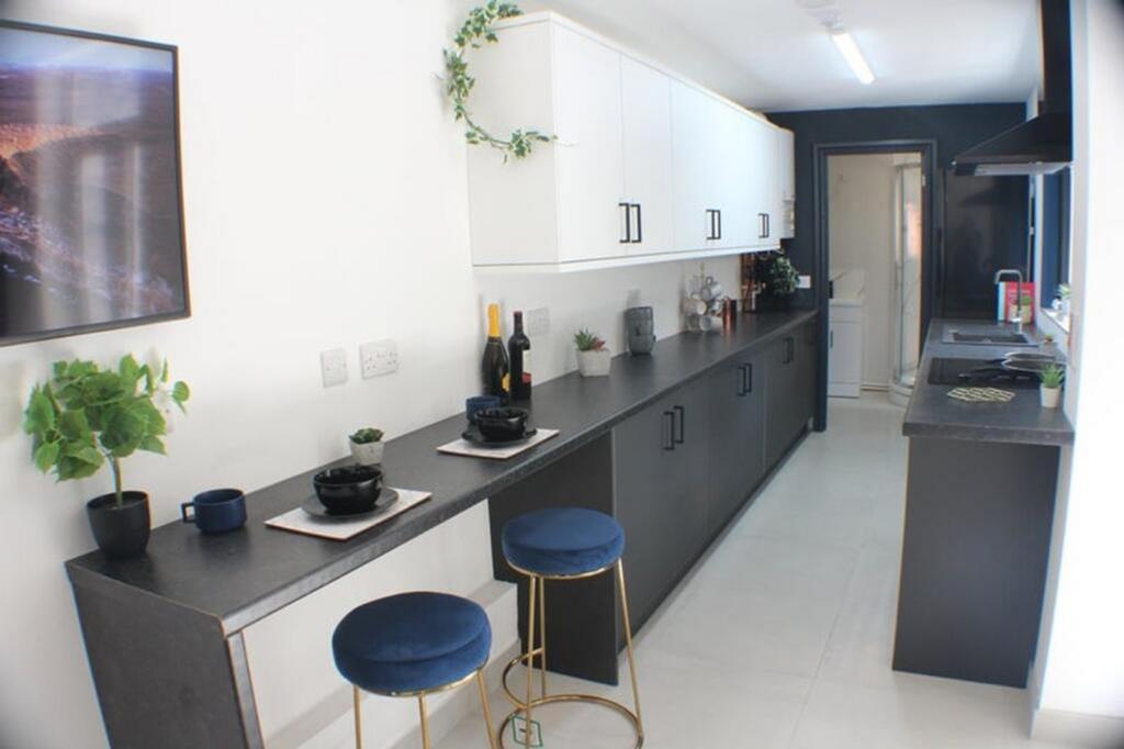A stylish and modern kitchen featuring sleek bl...
