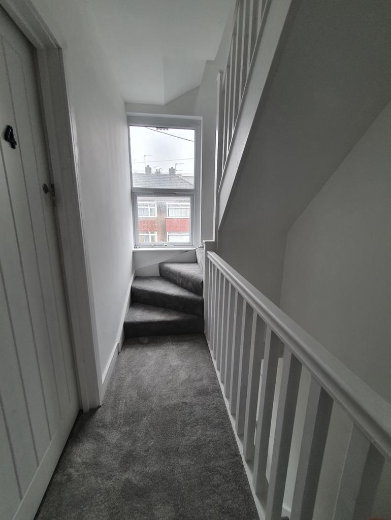 Bright and airy hallway featuring a stylish sta...
