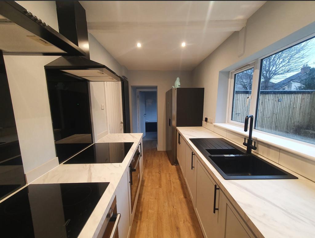 A modern kitchen featuring sleek cabinetry, amp...
