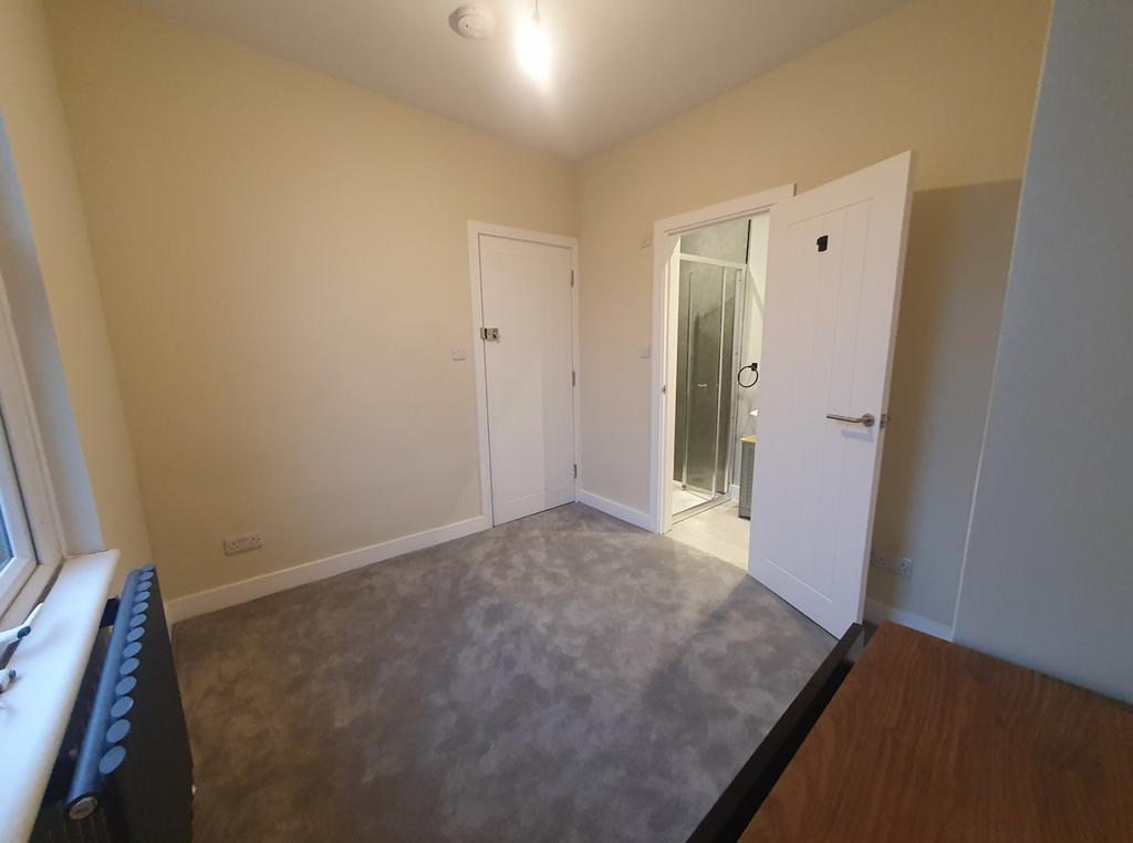 This inviting double bedroom features a cozy at...