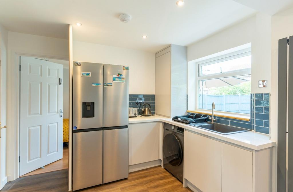 A modern and tidy kitchenette with ample natura...
