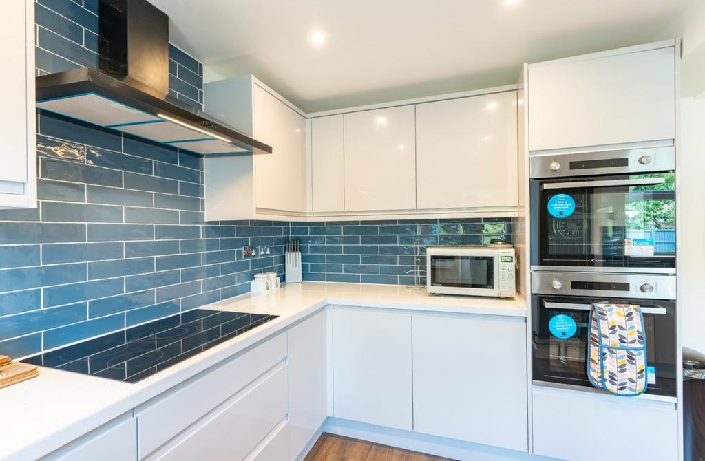 A modern and immaculate kitchen featuring sleek...