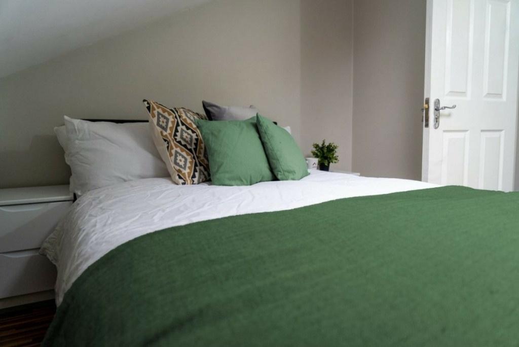 A spacious, well-presented bedroom featuring a ...