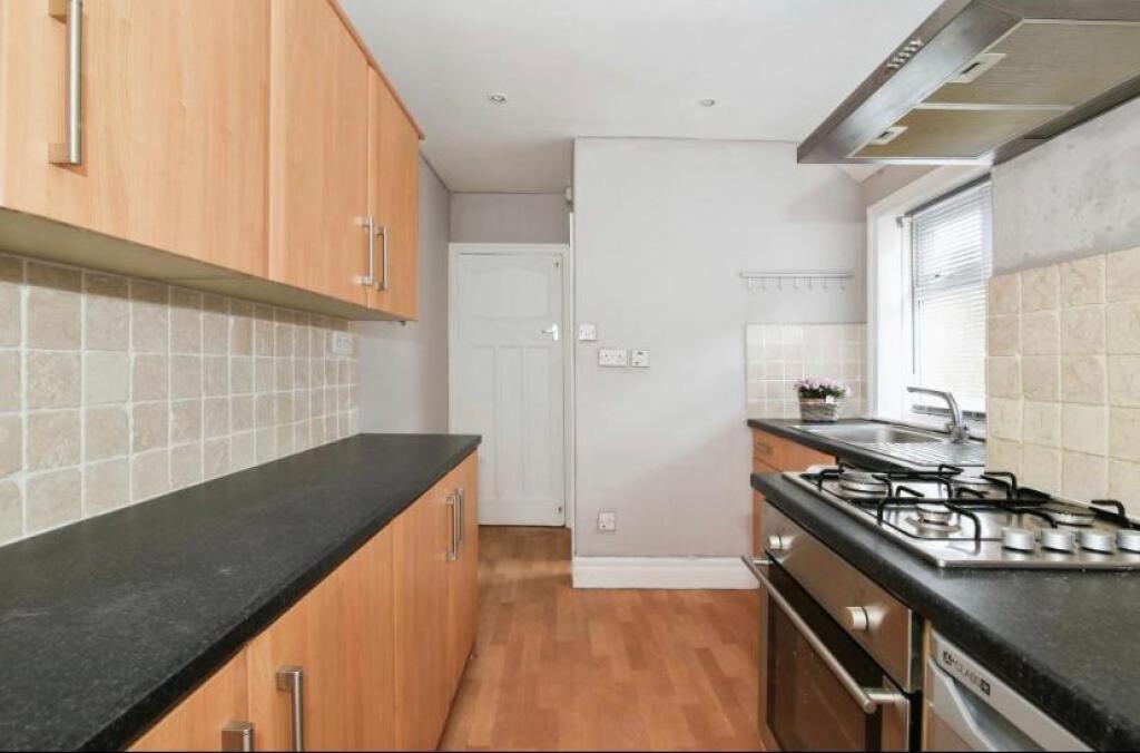 This kitchen features modern cabinetry and ampl...