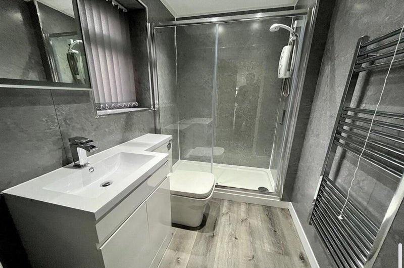 A modern bathroom featuring a sleek white sink ...