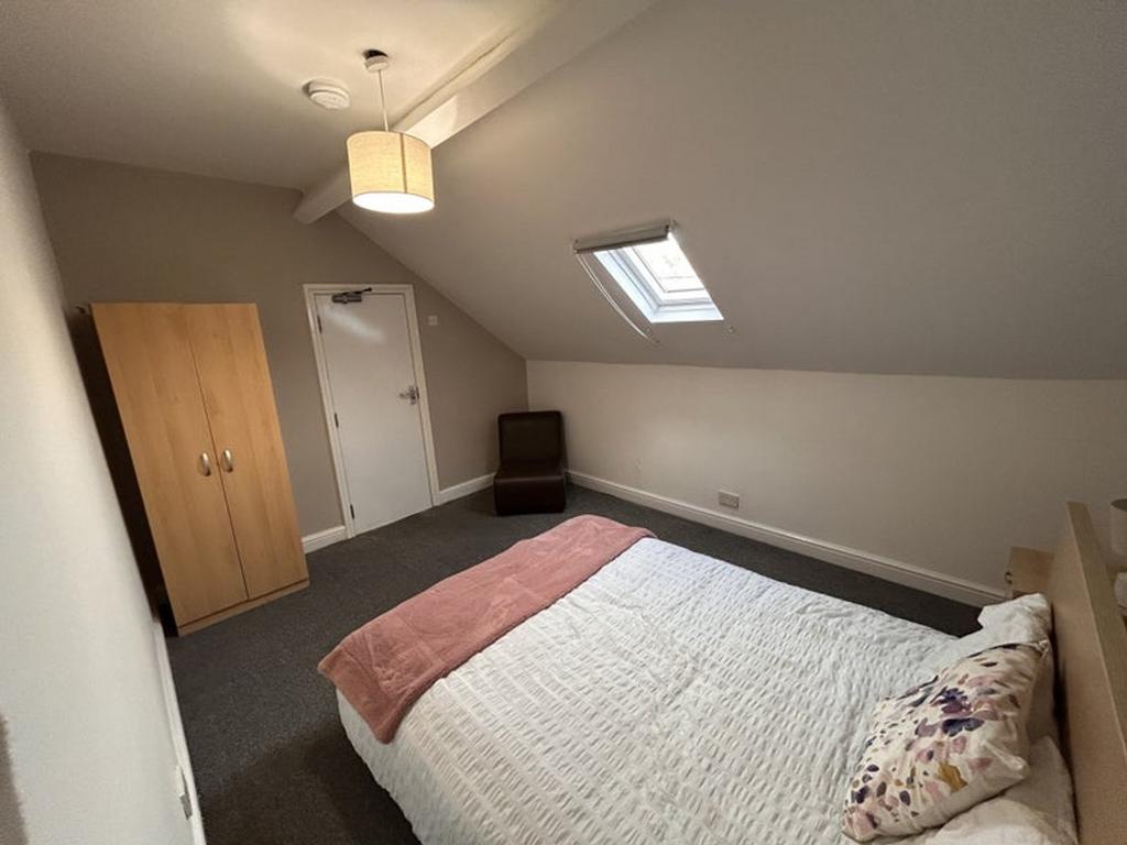 Spacious double bedroom featuring a cozy bed, a...