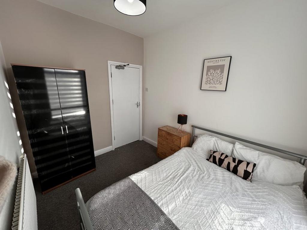This inviting double bedroom features a cozy la...