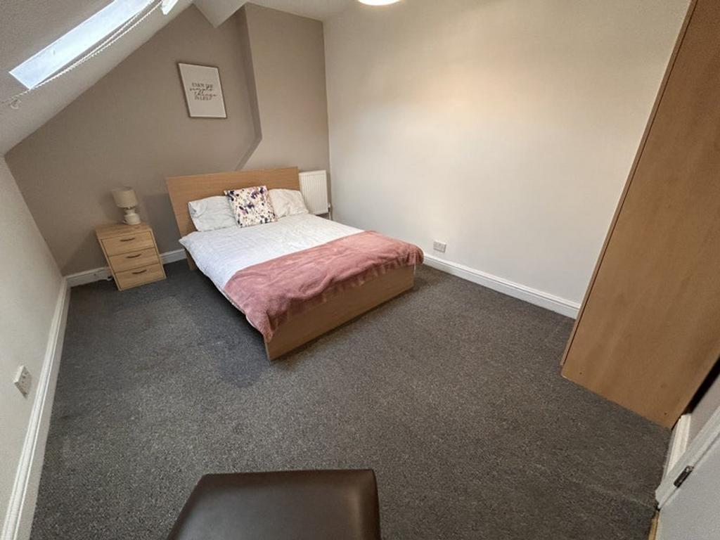 A cozy double bedroom featuring a comfortable b...