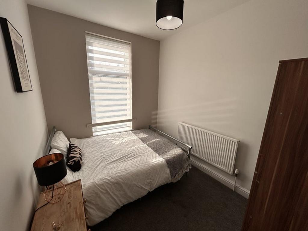 A cozy double bedroom featuring ample natural l...