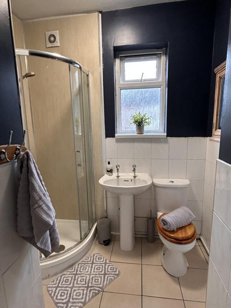 A modern bathroom featuring a spacious shower a...