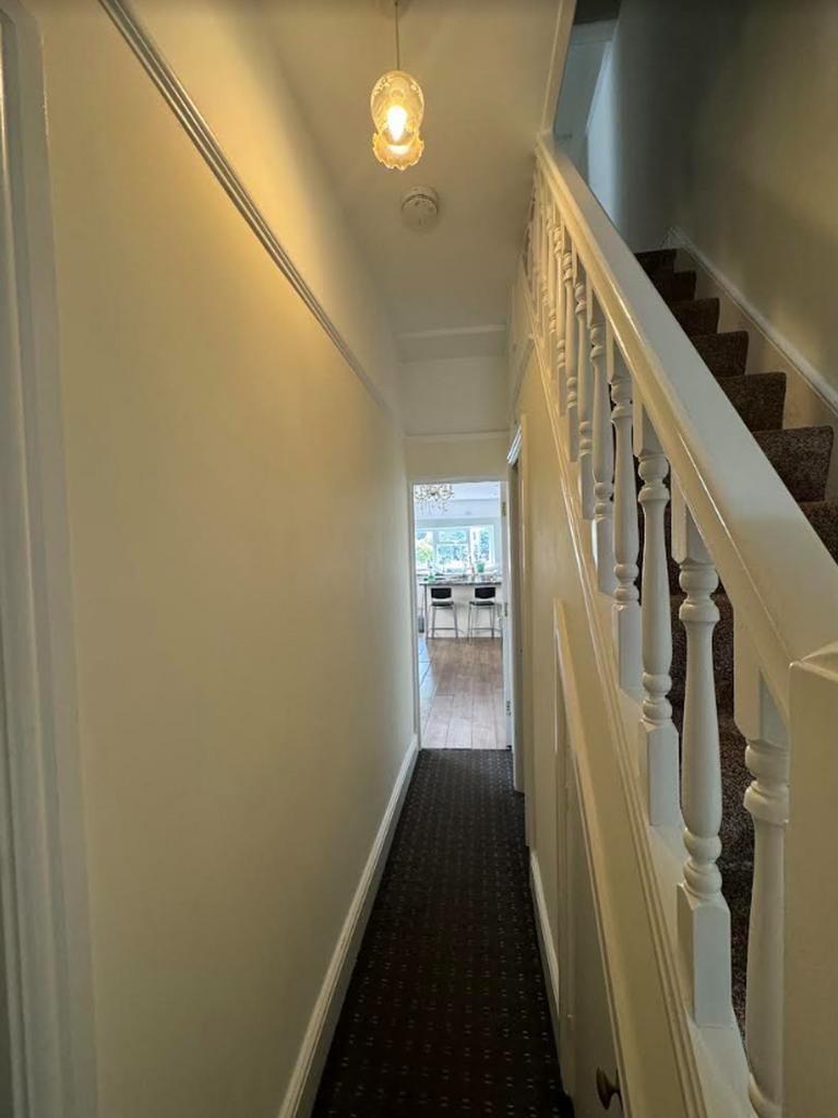 A tidy and well-lit hallway leading to the main...