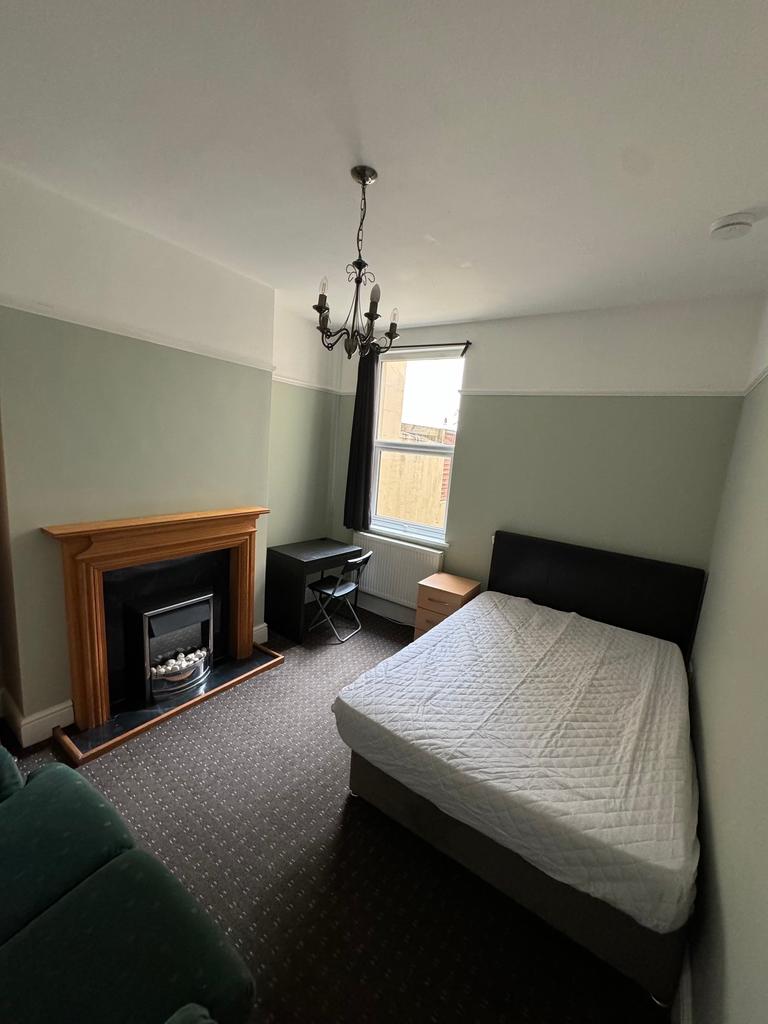 This inviting double bedroom features a cozy at...