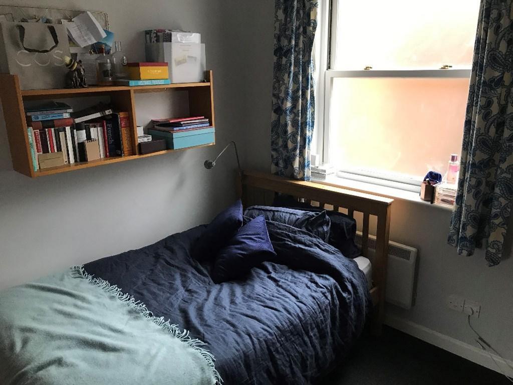This inviting double bedroom features a cozy be...