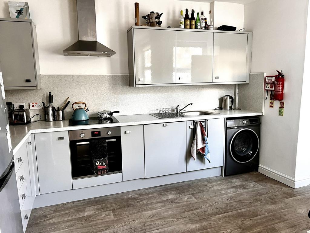 Modern kitchen featuring sleek cabinetry, a was...