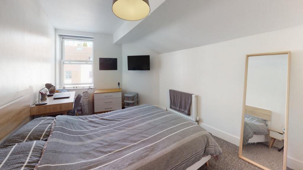 A cozy double bedroom featuring natural light f...