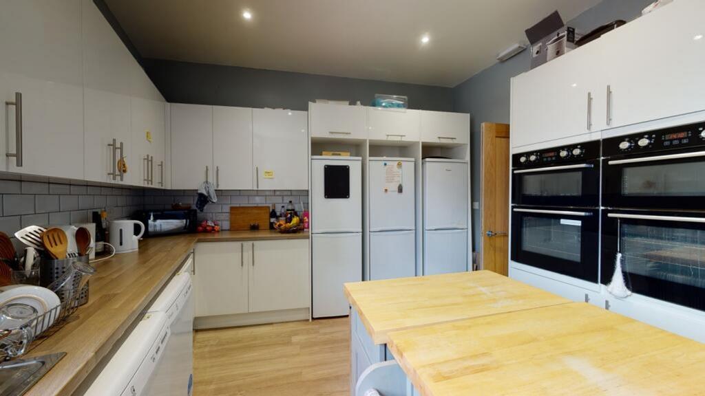 A modern kitchen featuring sleek cabinetry, amp...