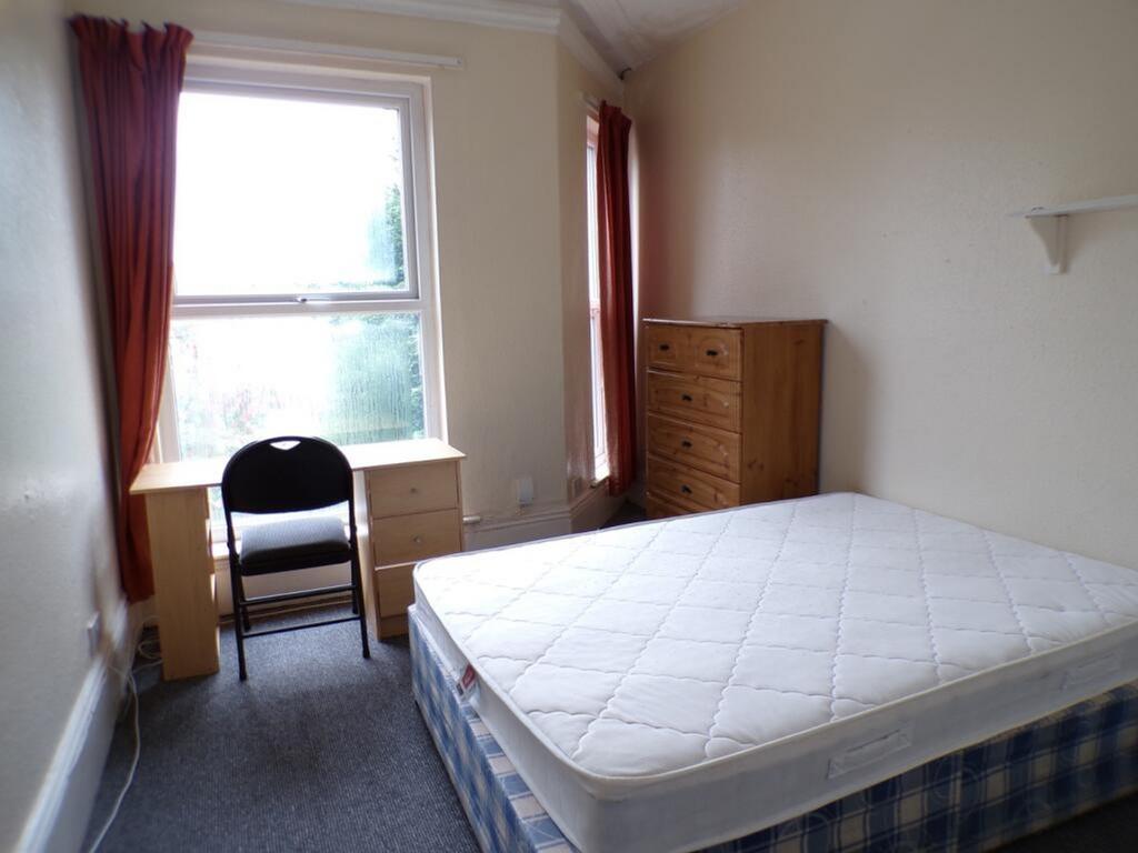 This inviting double bedroom features a comfort...