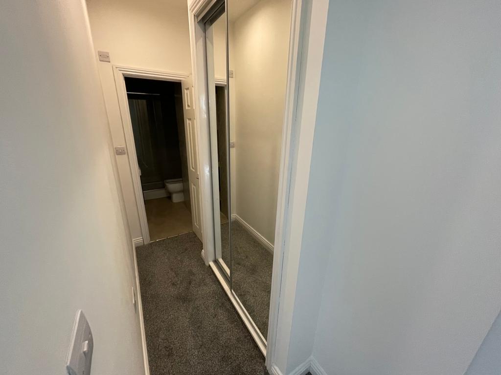 A well-maintained hallway featuring a mirrored ...