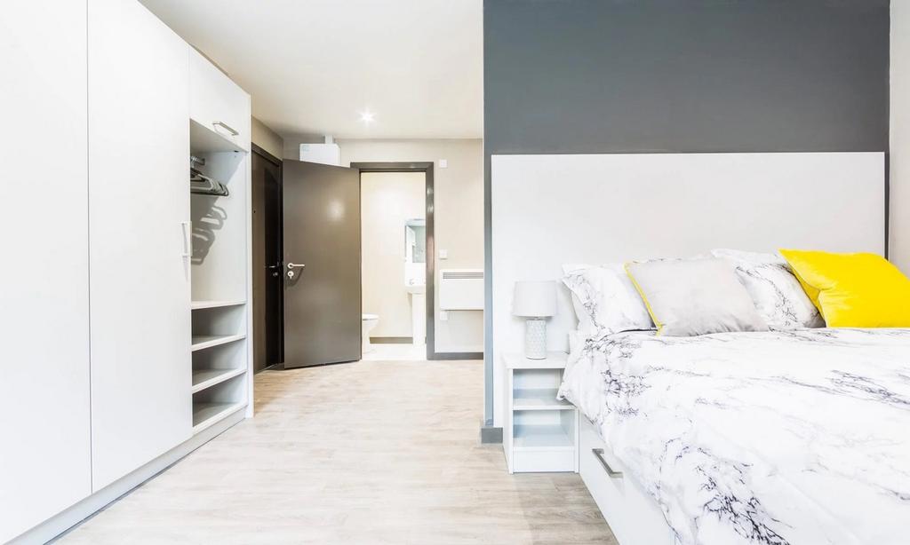 A bright and modern double bedroom featuring st...