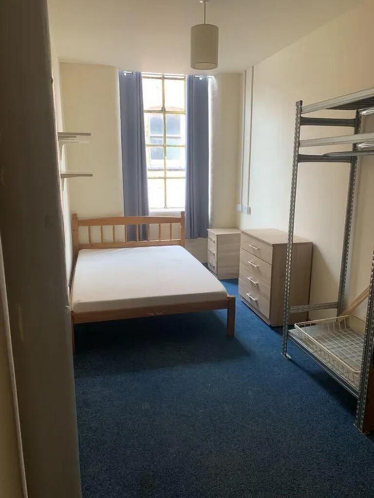 This spacious double bedroom features large win...