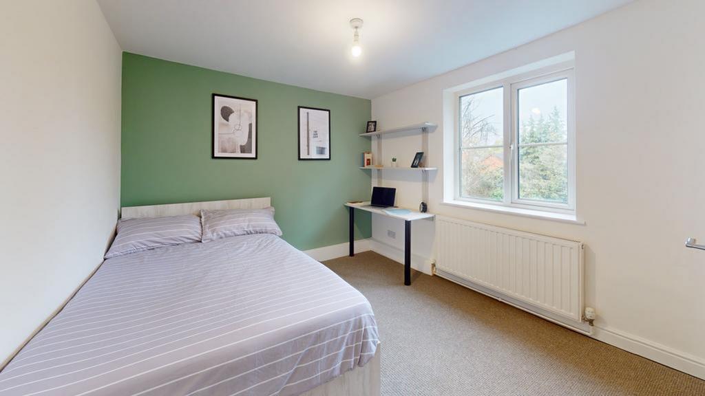 A bright and inviting double bedroom with a com...