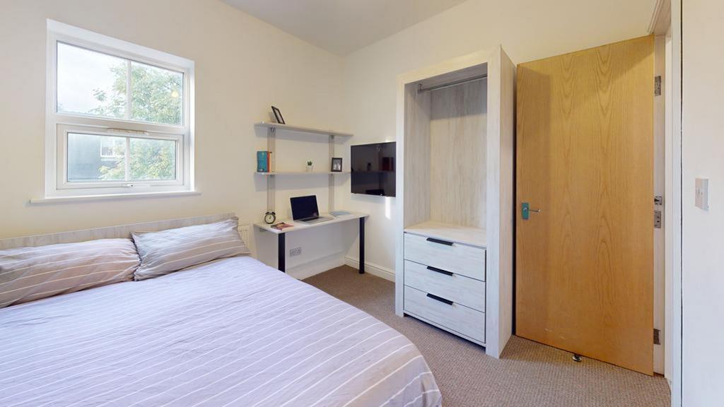A bright and tidy double bedroom featuring a wo...