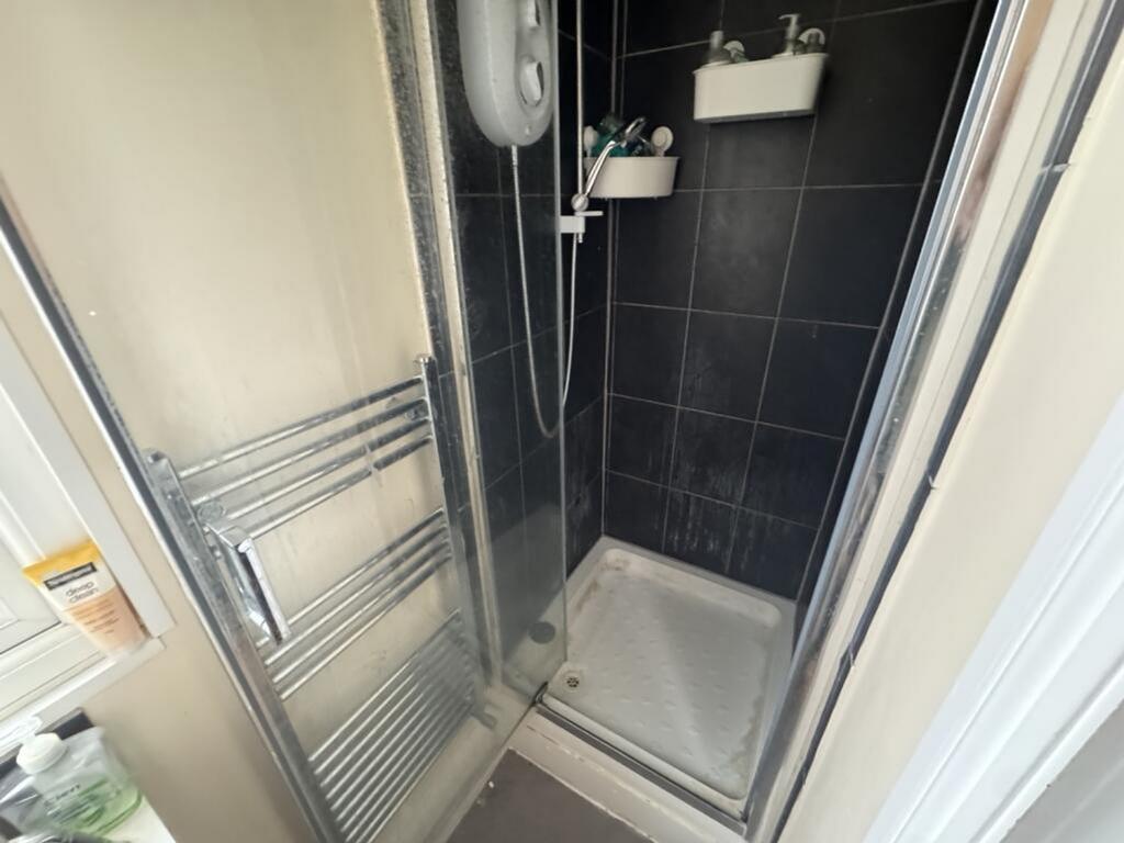 A modern shower area featuring sleek black tile...