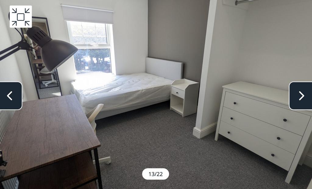 A bright and spacious double bedroom with styli...