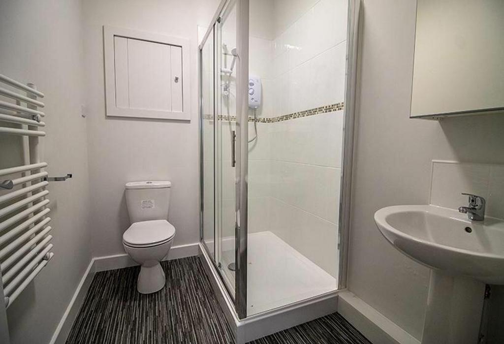 A modern bathroom featuring a spacious shower, ...