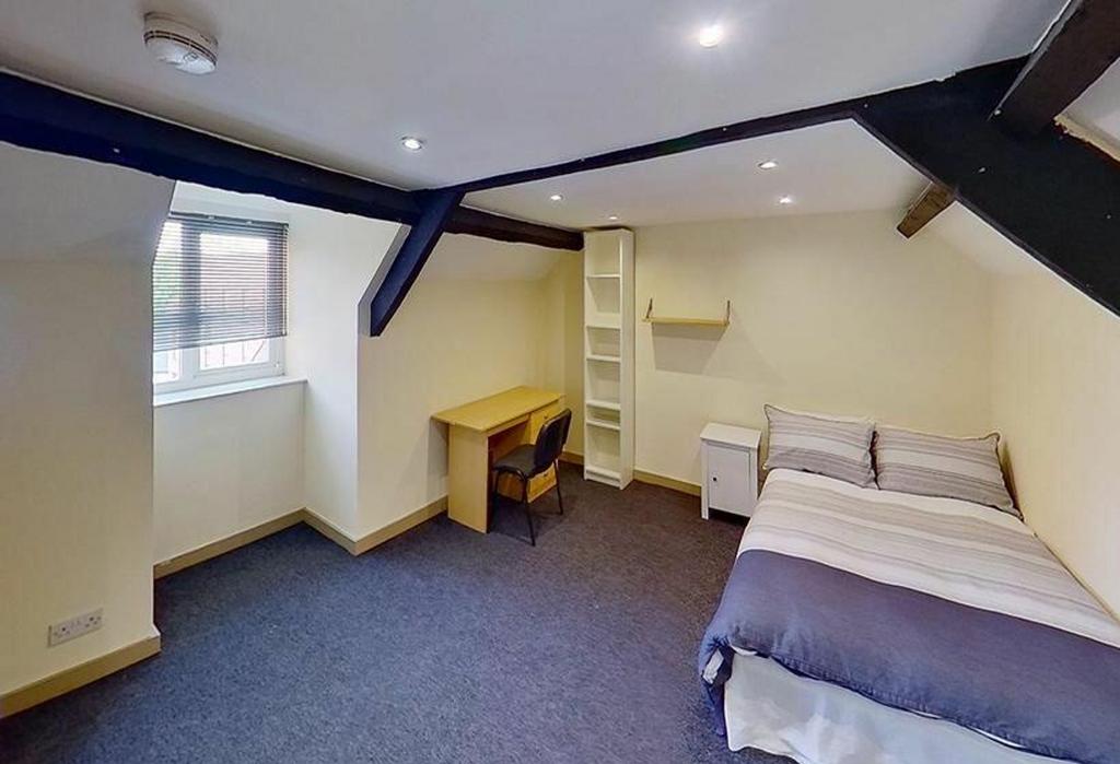 This inviting double bedroom features a cozy at...