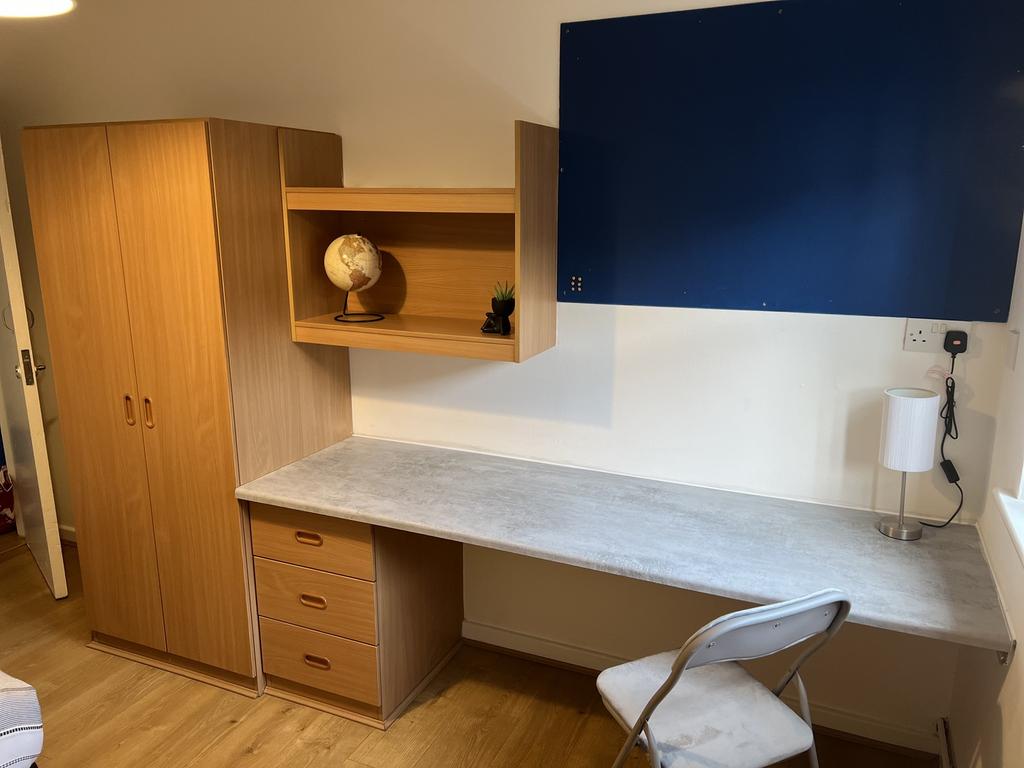 This cozy double bedroom features ample storage...