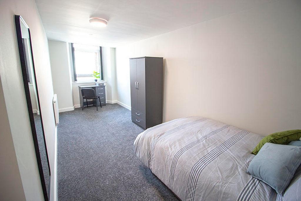 A spacious double bedroom featuring a comfortab...