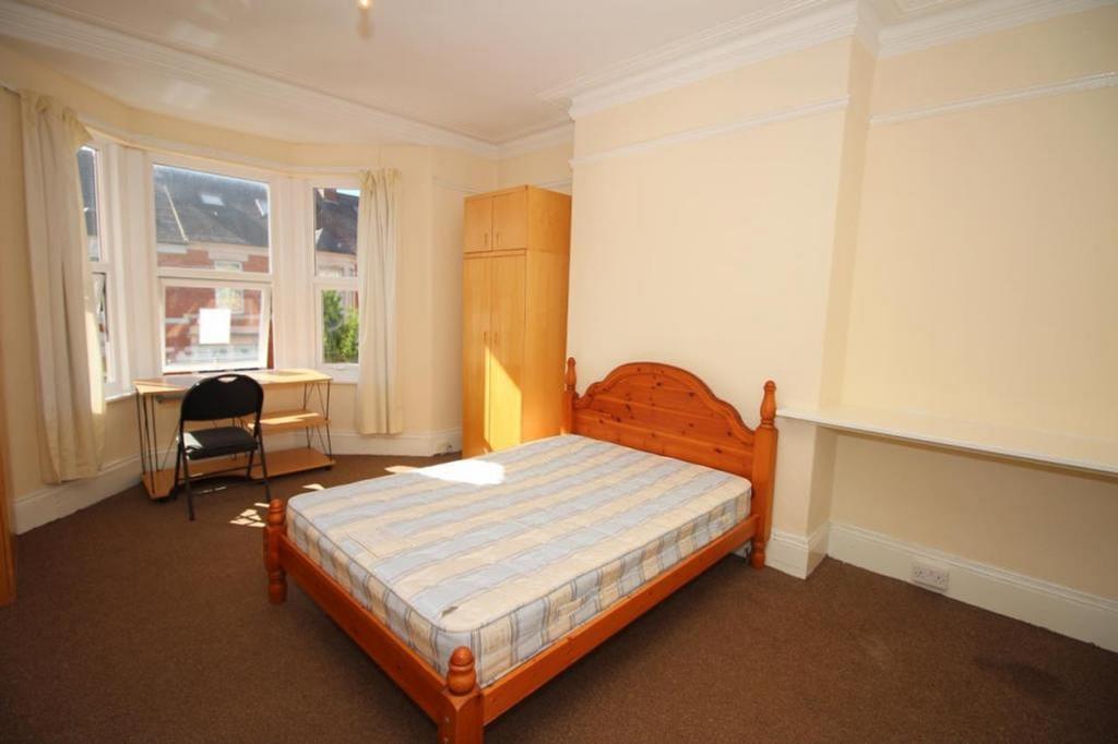 Spacious double bedroom featuring large windows...