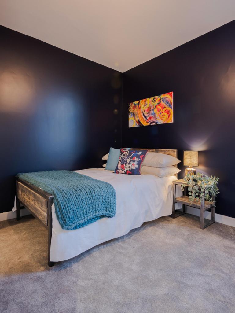This stylish double bedroom features a cozy atm...