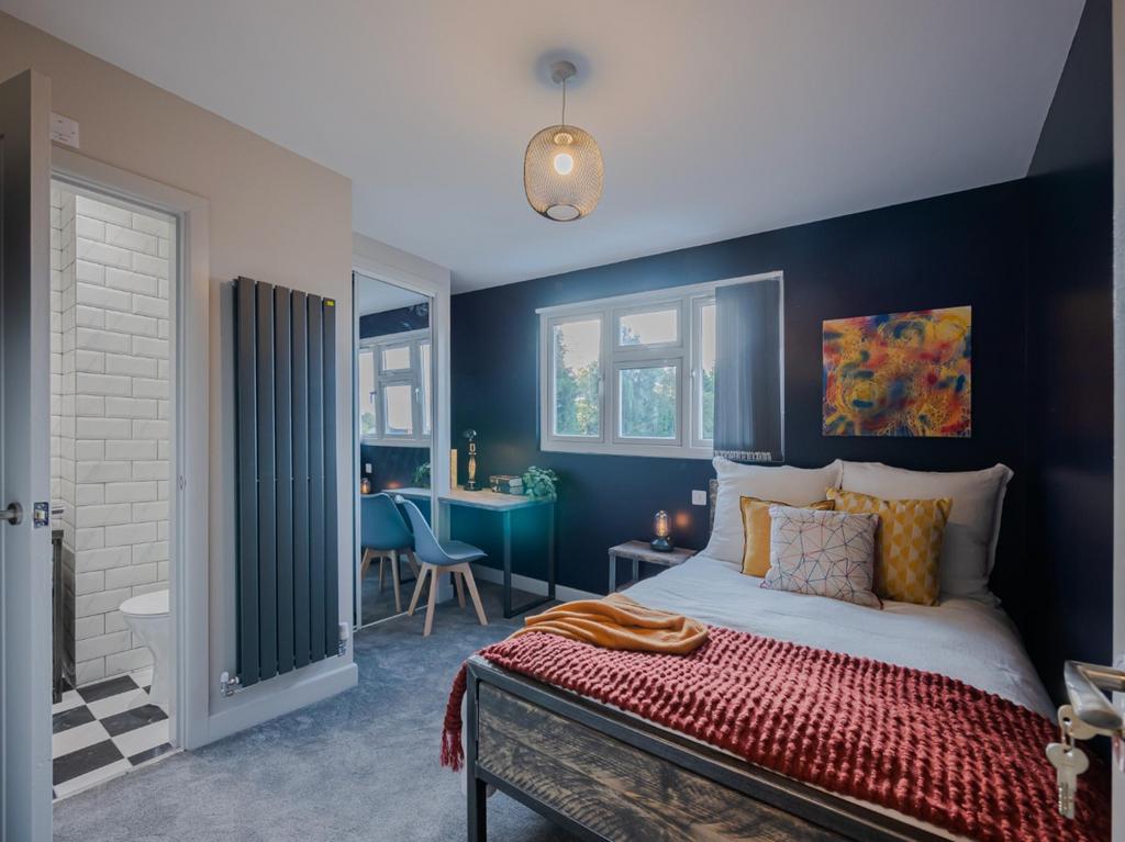 This stylish double bedroom features a cozy bed...