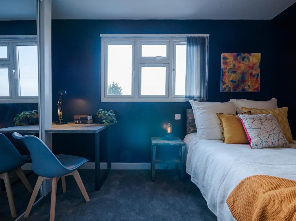 This inviting double bedroom features a cozy at...